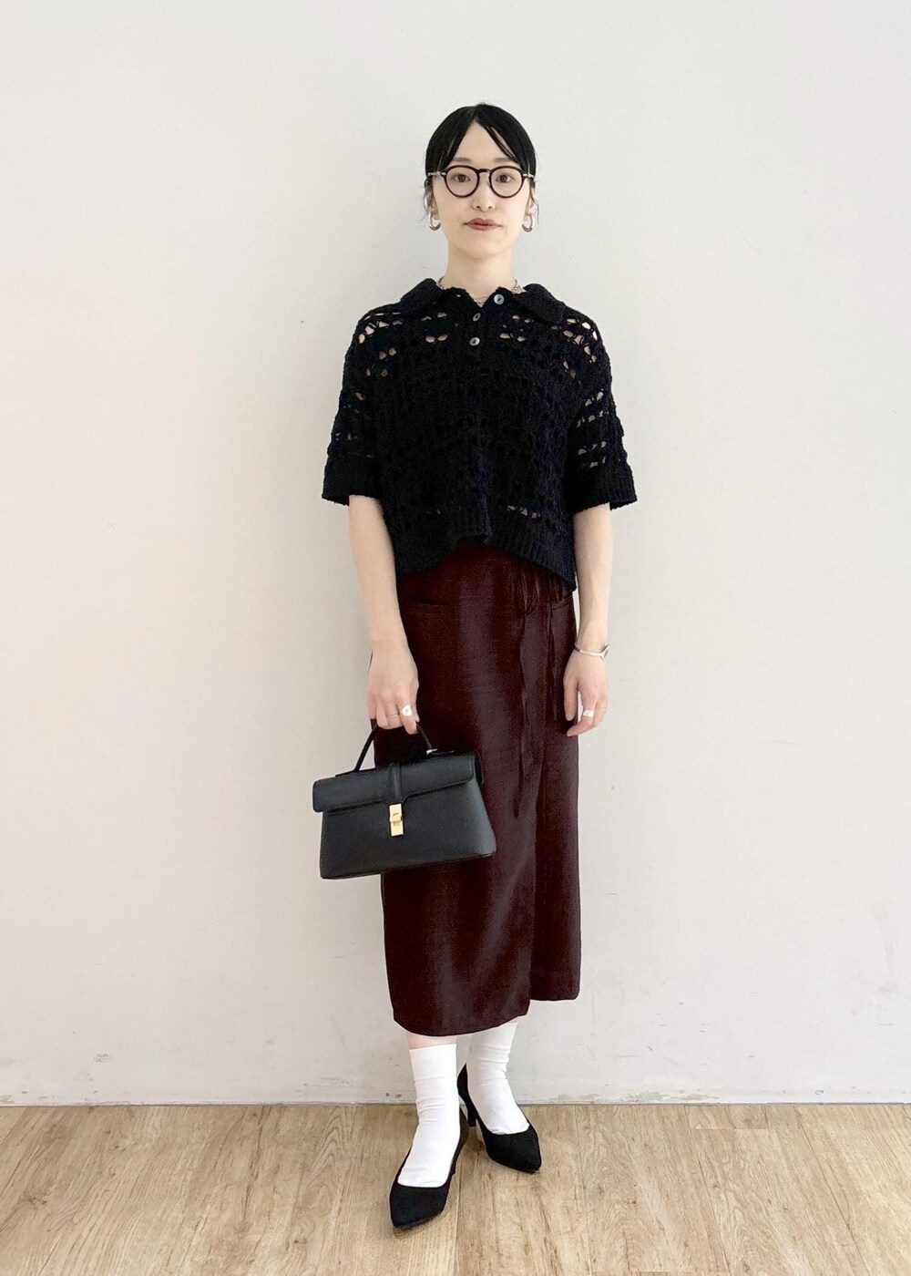 ブラック系のパンプス、ホワイト系のキャミソール、ブラック系のショルダーバッグを着用したレディースの夏コーディネートの7枚目の写真