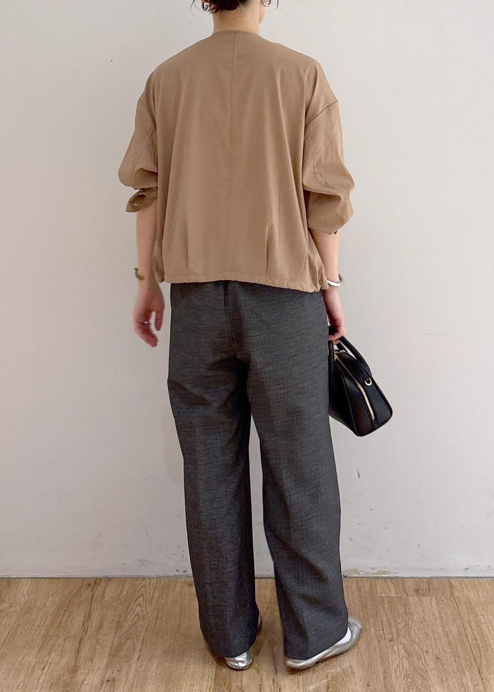 ベージュ系のブルゾン、グレー系のスラックス、ブラック系のショルダーバッグを着用したレディースの秋コーディネートの4枚目の写真