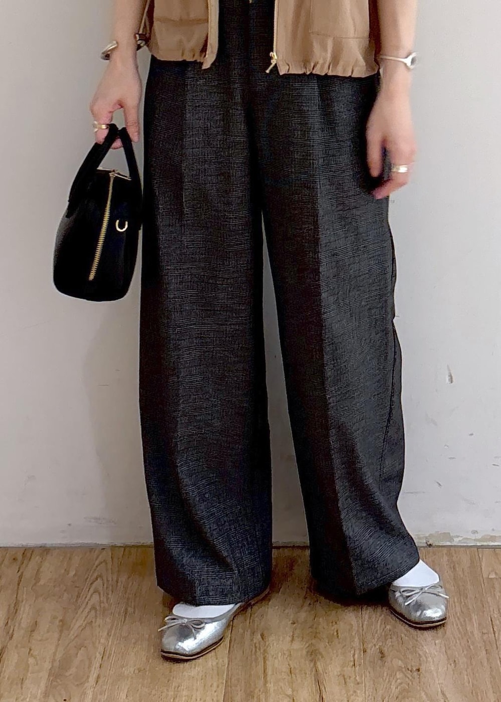 ベージュ系のブルゾン、グレー系のスラックス、ブラック系のショルダーバッグを着用したレディースの秋コーディネートの6枚目の写真