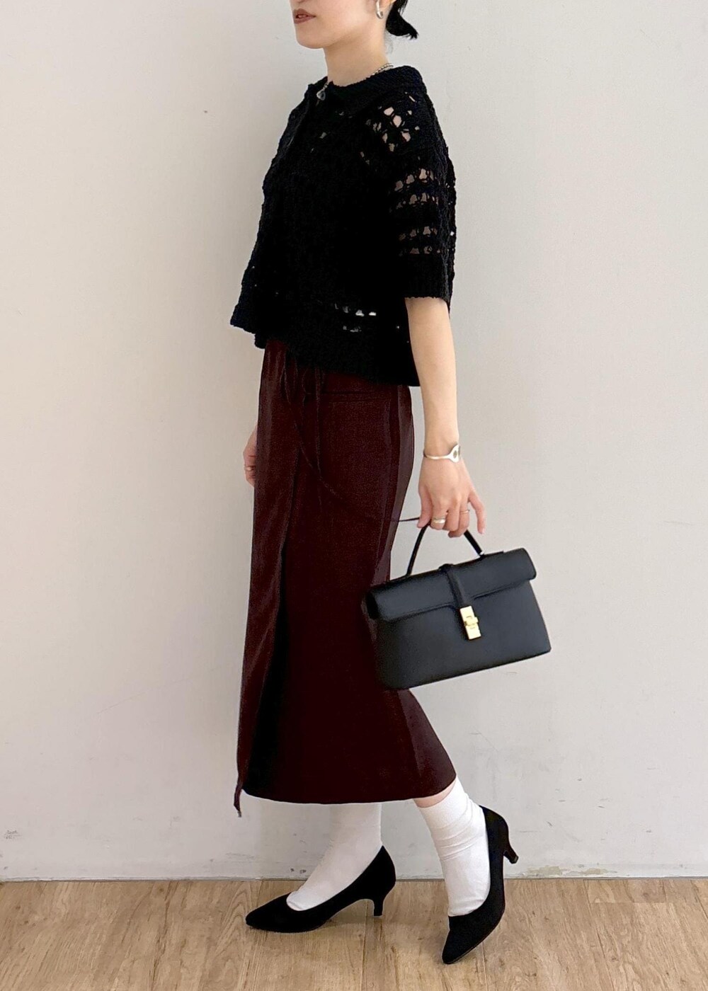 ブラック系のパンプス、ホワイト系のキャミソール、ブラック系のショルダーバッグを着用したレディースの夏コーディネートの3枚目の写真