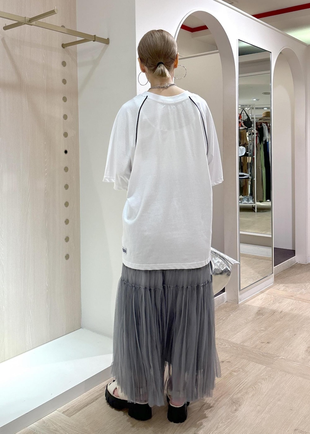 ホワイト系のサンダル、グレー系のスカート、ホワイト系のTシャツ/カットソーを着用したレディースの夏コーディネートの3枚目の写真