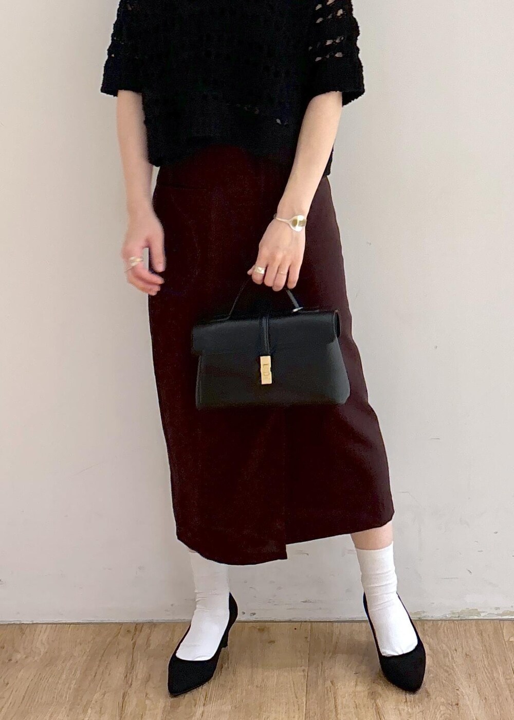 ブラック系のパンプス、ホワイト系のキャミソール、ブラック系のショルダーバッグを着用したレディースの夏コーディネートの2枚目の写真