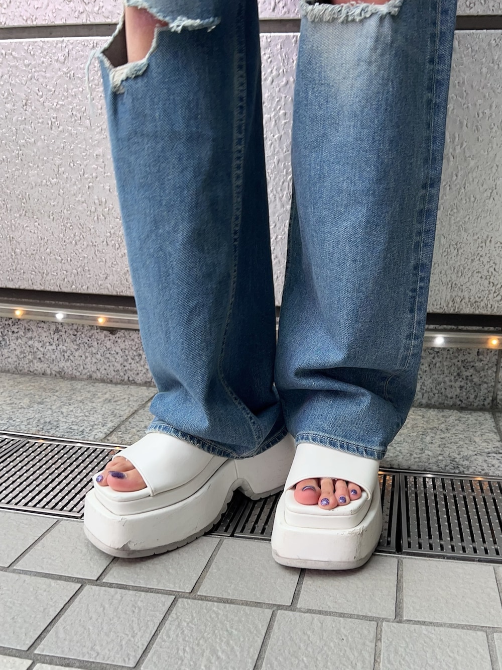 ホワイト系のキャミソール、ブルー系のデニムパンツ、ホワイト系のサンダルを着用したレディースの夏コーディネートの6枚目の写真