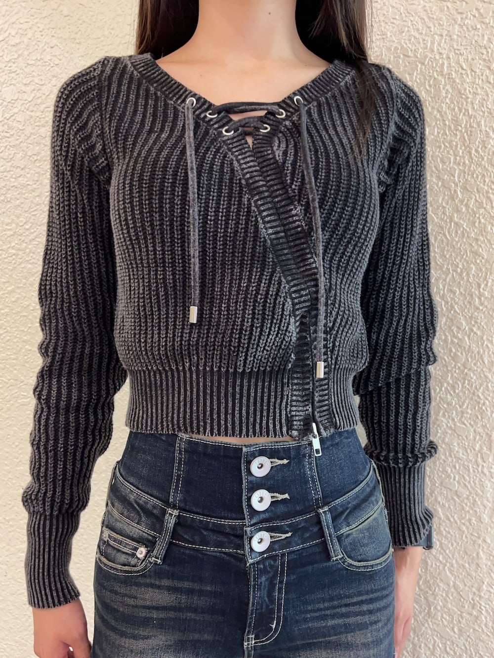 ブルー系のデニムパンツ、ブラック系のニット/セーター、ブラック系のブーツを着用したレディースの秋コーディネートの4枚目の写真