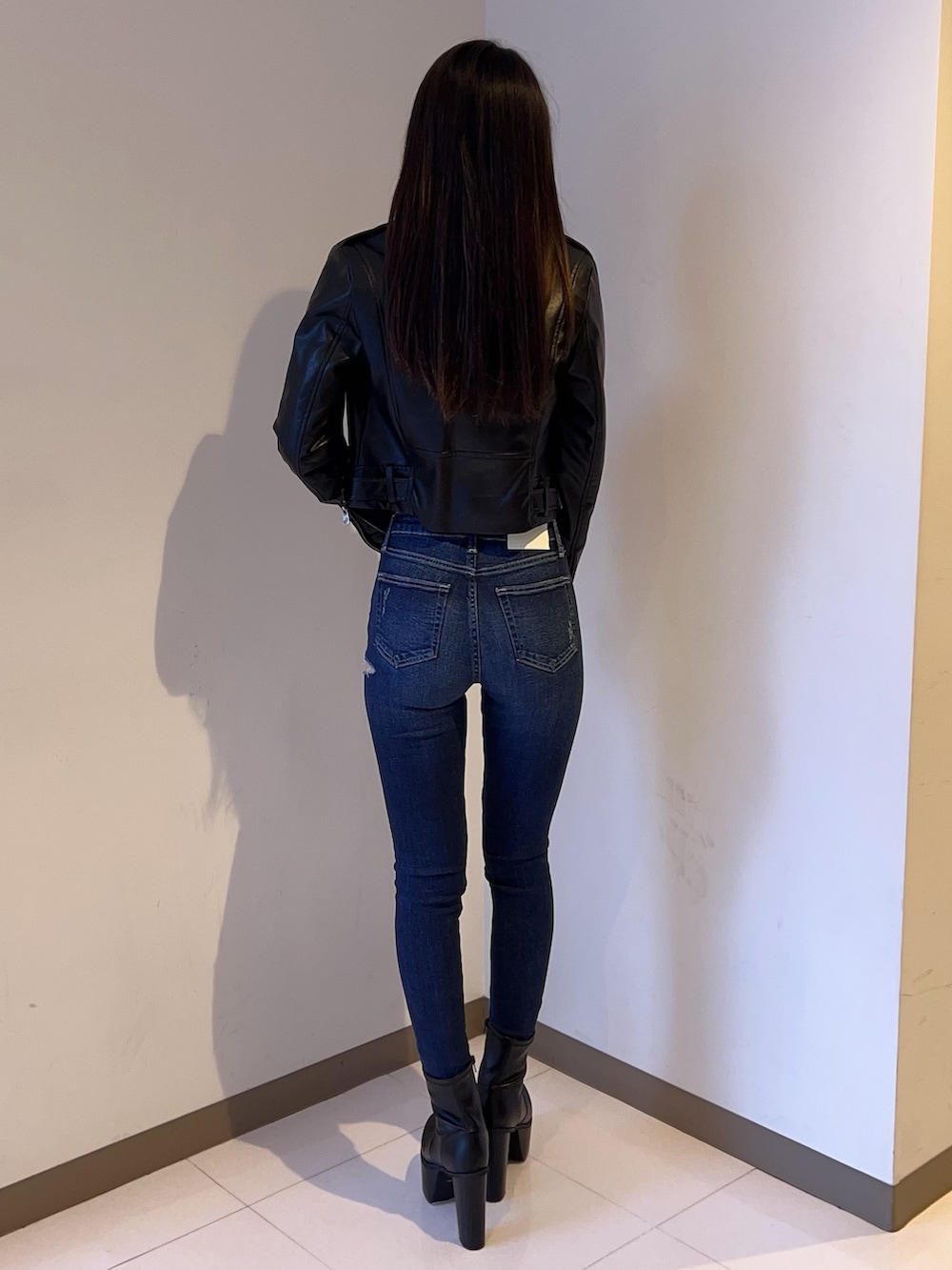 ブラック系のライダースジャケット、ブラック系のニット/セーター、ブルー系のデニムパンツを着用したレディースの夏コーディネートの3枚目の写真