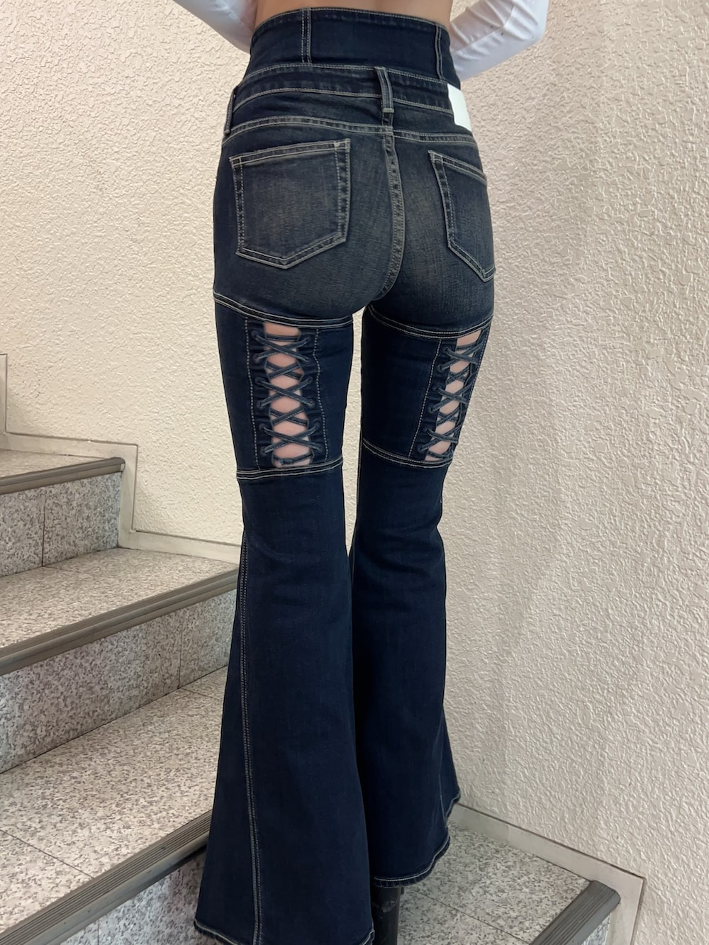 ブルー系のデニムパンツ、ブラック系のニット/セーター、ブラック系のブーツを着用したレディースの秋コーディネートの5枚目の写真