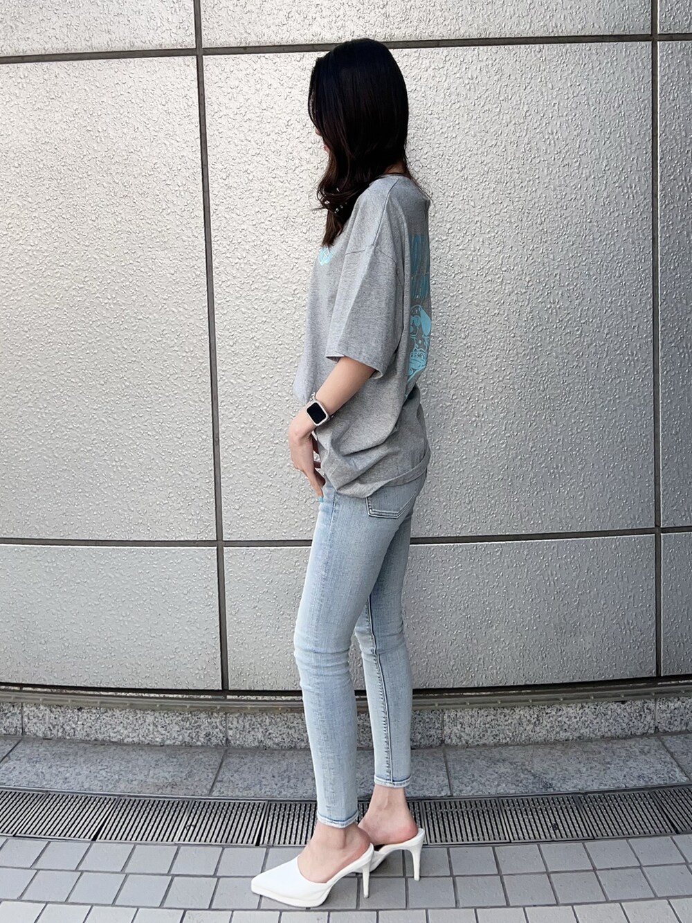 グレー系のTシャツ/カットソー、ブルー系のデニムパンツ、ホワイト系のパンプスを着用したレディースの春コーディネートの2枚目の写真