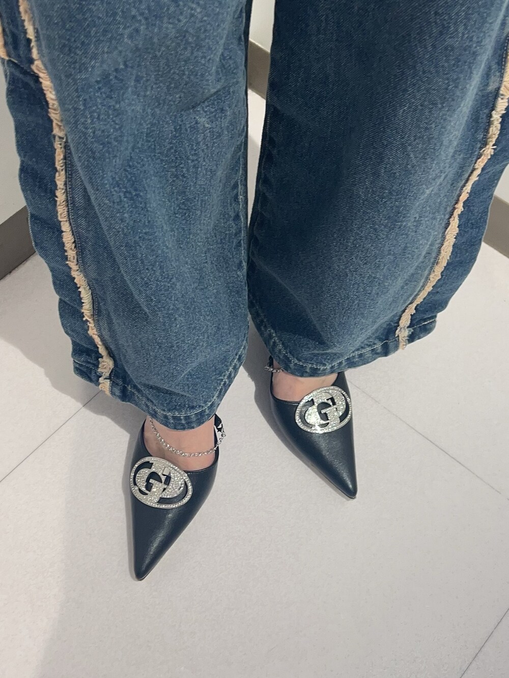 ホワイト系のTシャツ/カットソー、ブルー系のデニムパンツ、ブラック系のパンプスを着用したレディースの秋コーディネートの6枚目の写真