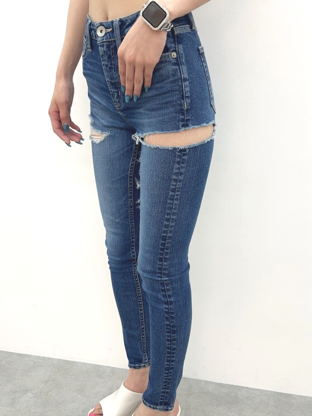 ホワイト系のサンダル、ホワイト系のキャミソール、ブルー系のデニムパンツを着用したレディースの夏コーディネートの5枚目の写真