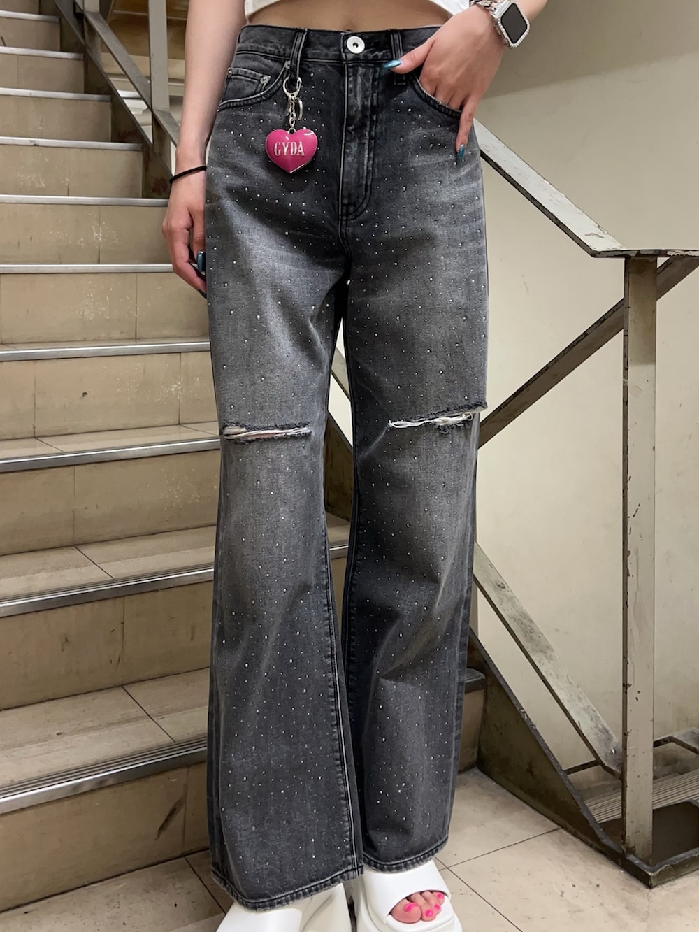 ホワイト系のTシャツ/カットソー、ブラック系のデニムパンツ、ホワイト系のサンダルを着用したレディースの春コーディネートの5枚目の写真