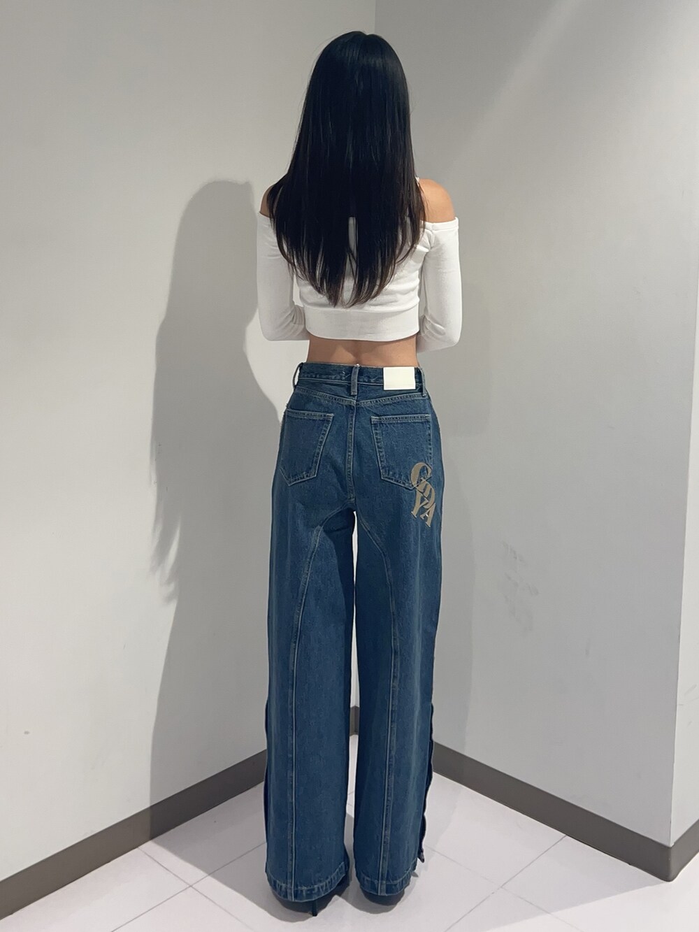 ホワイト系のTシャツ/カットソー、ブルー系のデニムパンツ、ブラック系のパンプスを着用したレディースの秋コーディネートの3枚目の写真