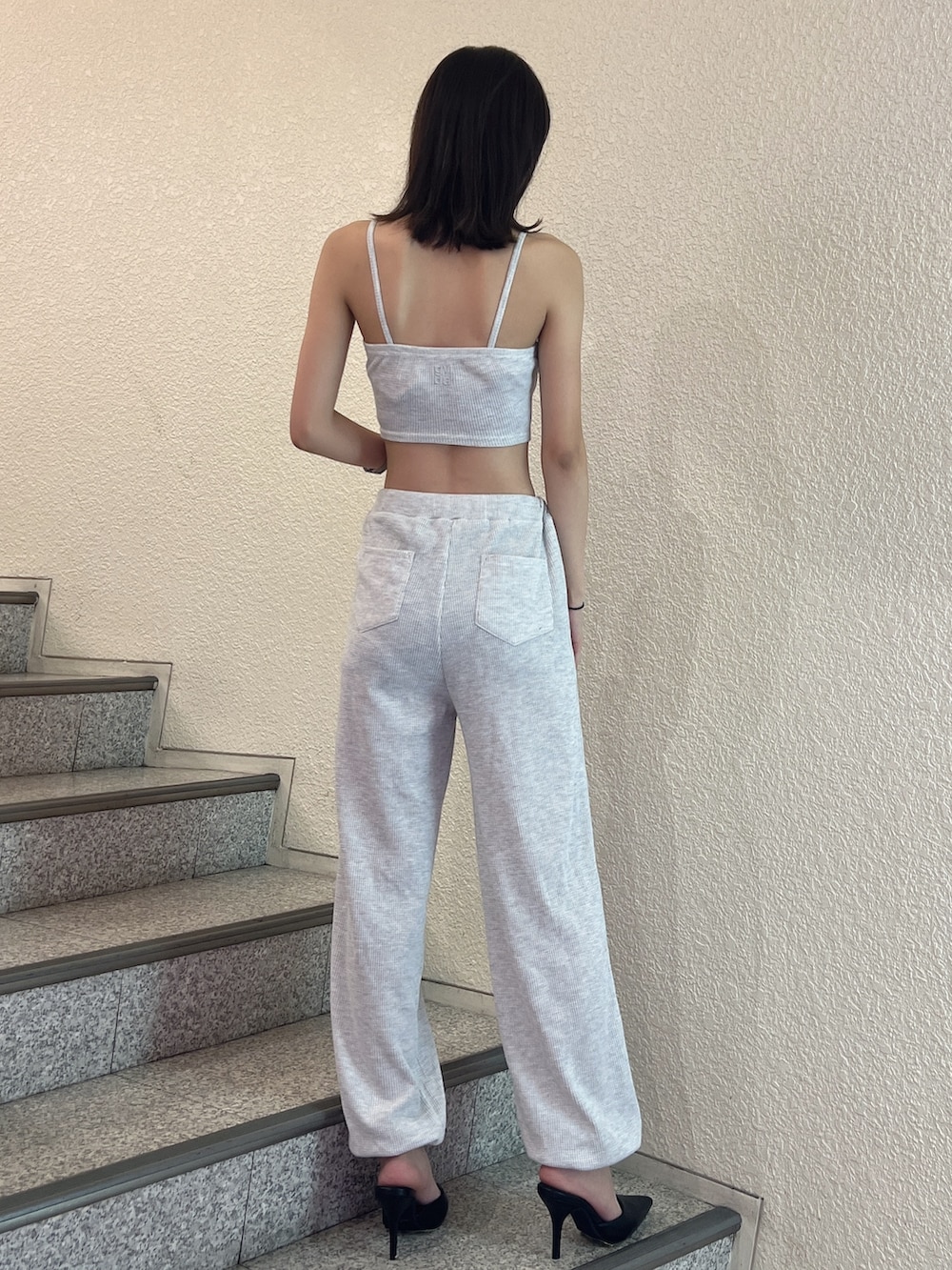 グレー系のスウェットパンツ、グレー系のキャミソール、ブラック系のパンプスを着用したレディースの夏コーディネートの4枚目の写真