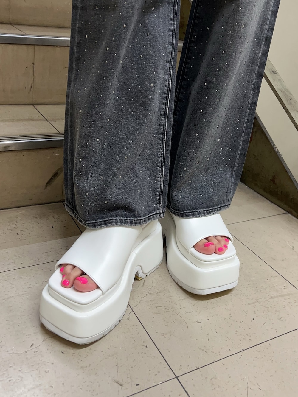 ホワイト系のTシャツ/カットソー、ブラック系のデニムパンツ、ホワイト系のサンダルを着用したレディースの春コーディネートの7枚目の写真