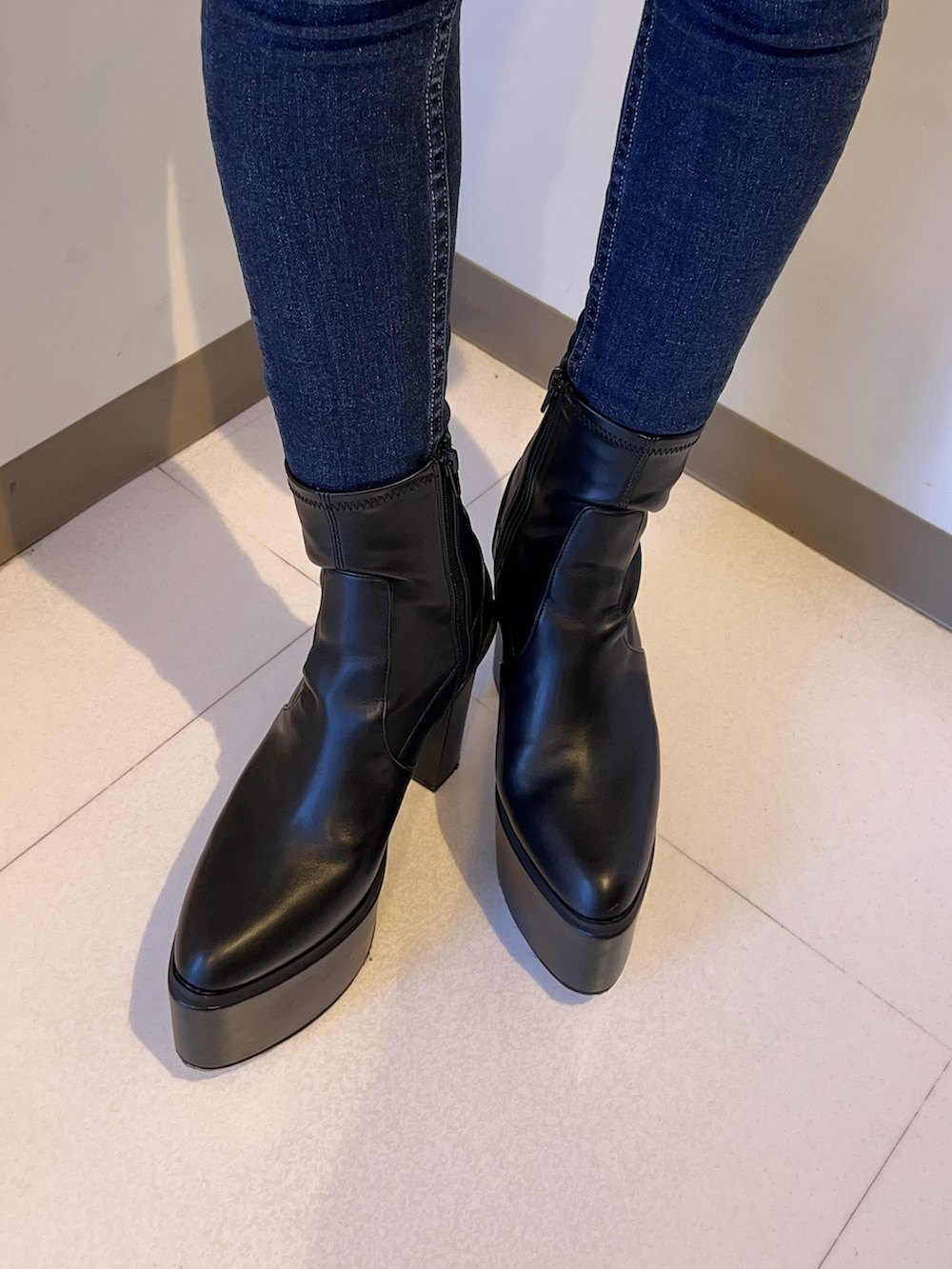 ブラック系のライダースジャケット、ブラック系のニット/セーター、ブルー系のデニムパンツを着用したレディースの夏コーディネートの6枚目の写真