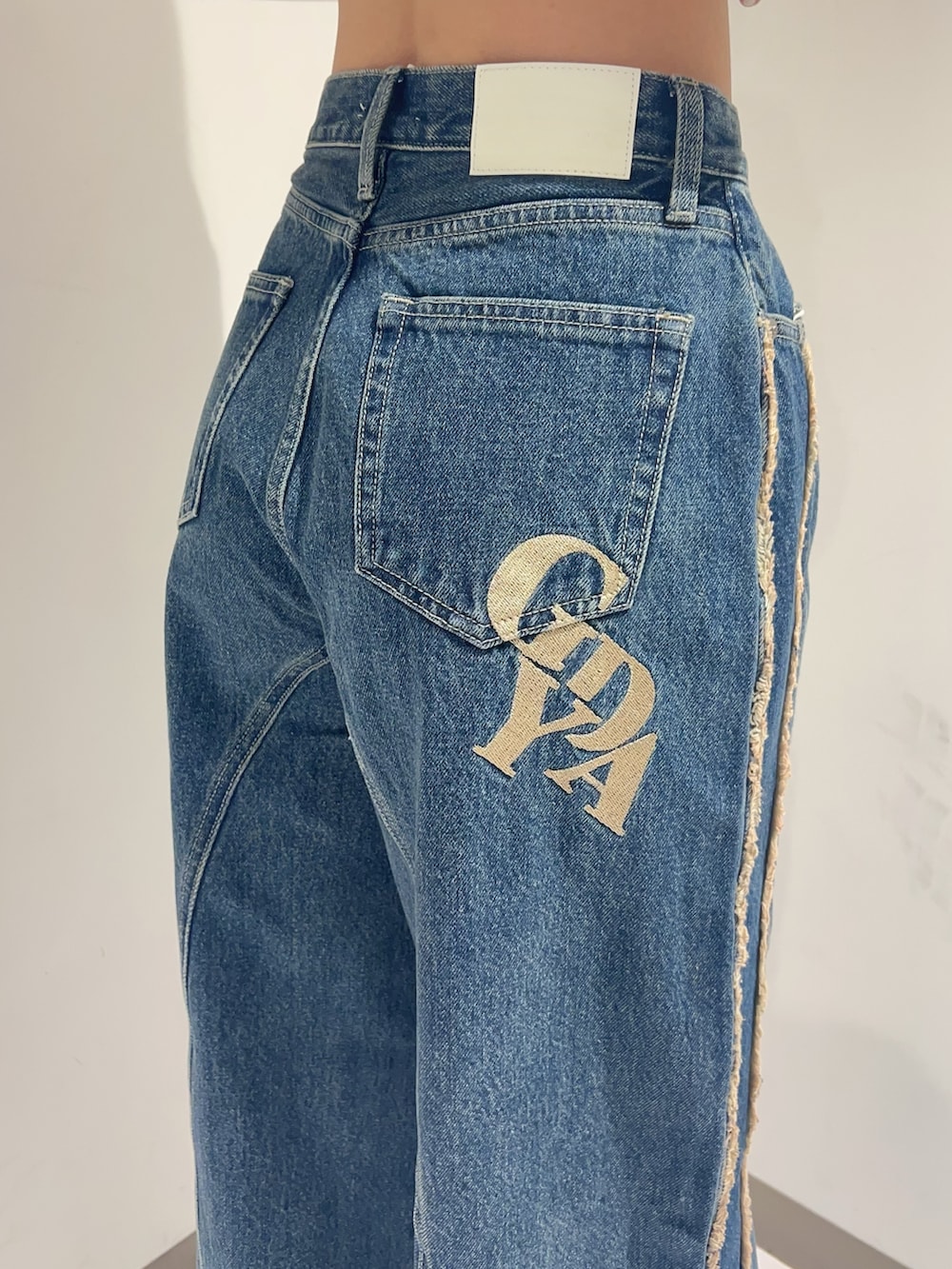 ホワイト系のTシャツ/カットソー、ブルー系のデニムパンツ、ブラック系のパンプスを着用したレディースの秋コーディネートの5枚目の写真