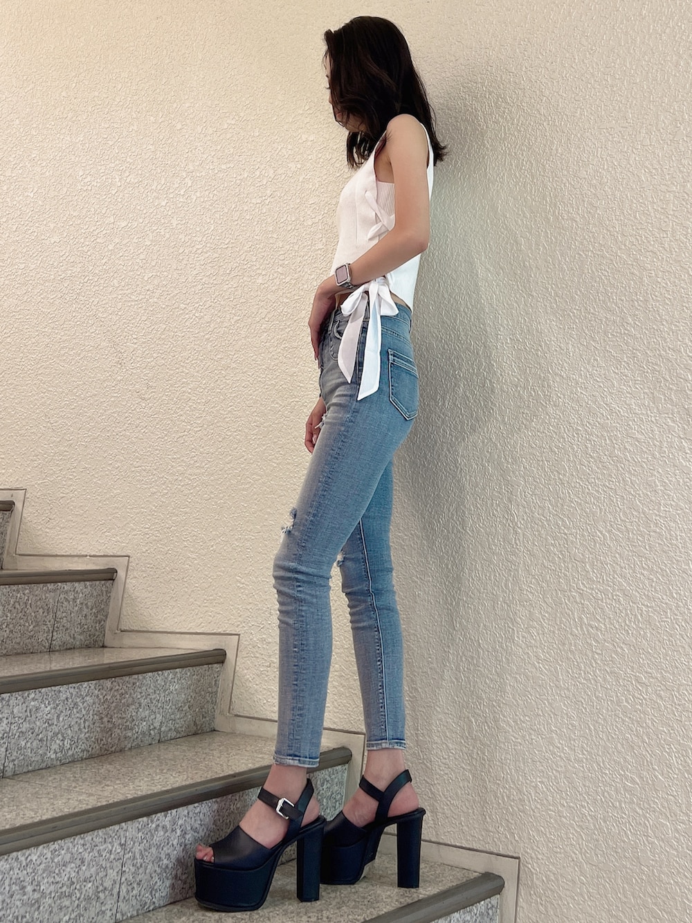 ホワイト系のニット/セーター、ブルー系のデニムパンツ、ブラック系のサンダルを着用したレディースの夏コーディネートの2枚目の写真