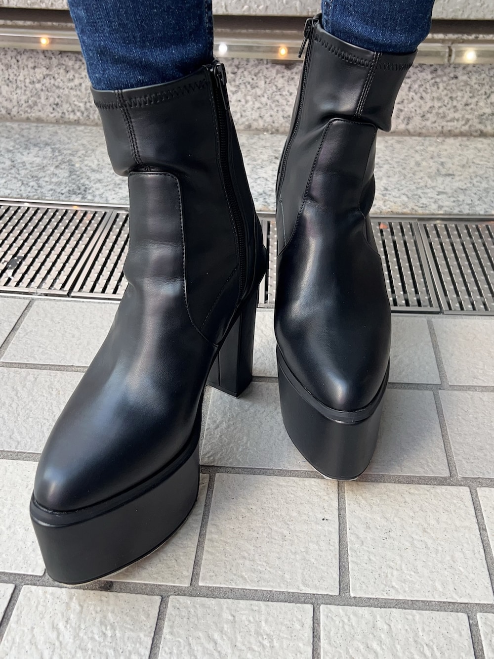 ブルー系のデニムパンツ、ブラック系のニット/セーター、ブラック系のブーツを着用したレディースの秋コーディネートの6枚目の写真