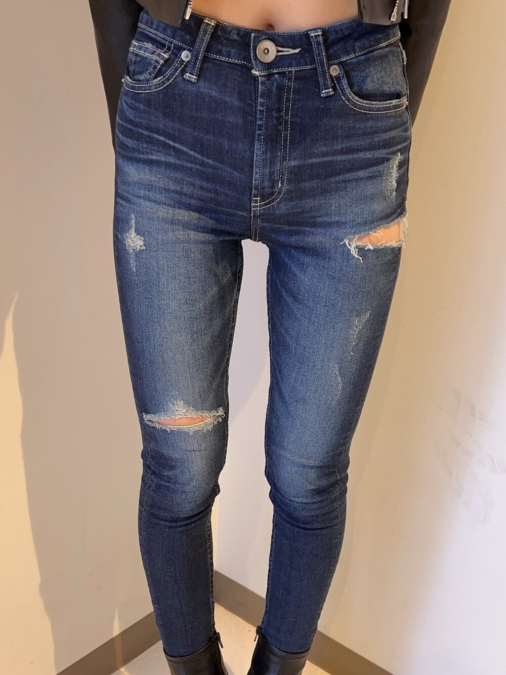 ホワイト系のスウェット、ブルー系のデニムパンツ、ブラック系のブーツを着用したレディースの夏コーディネートの6枚目の写真