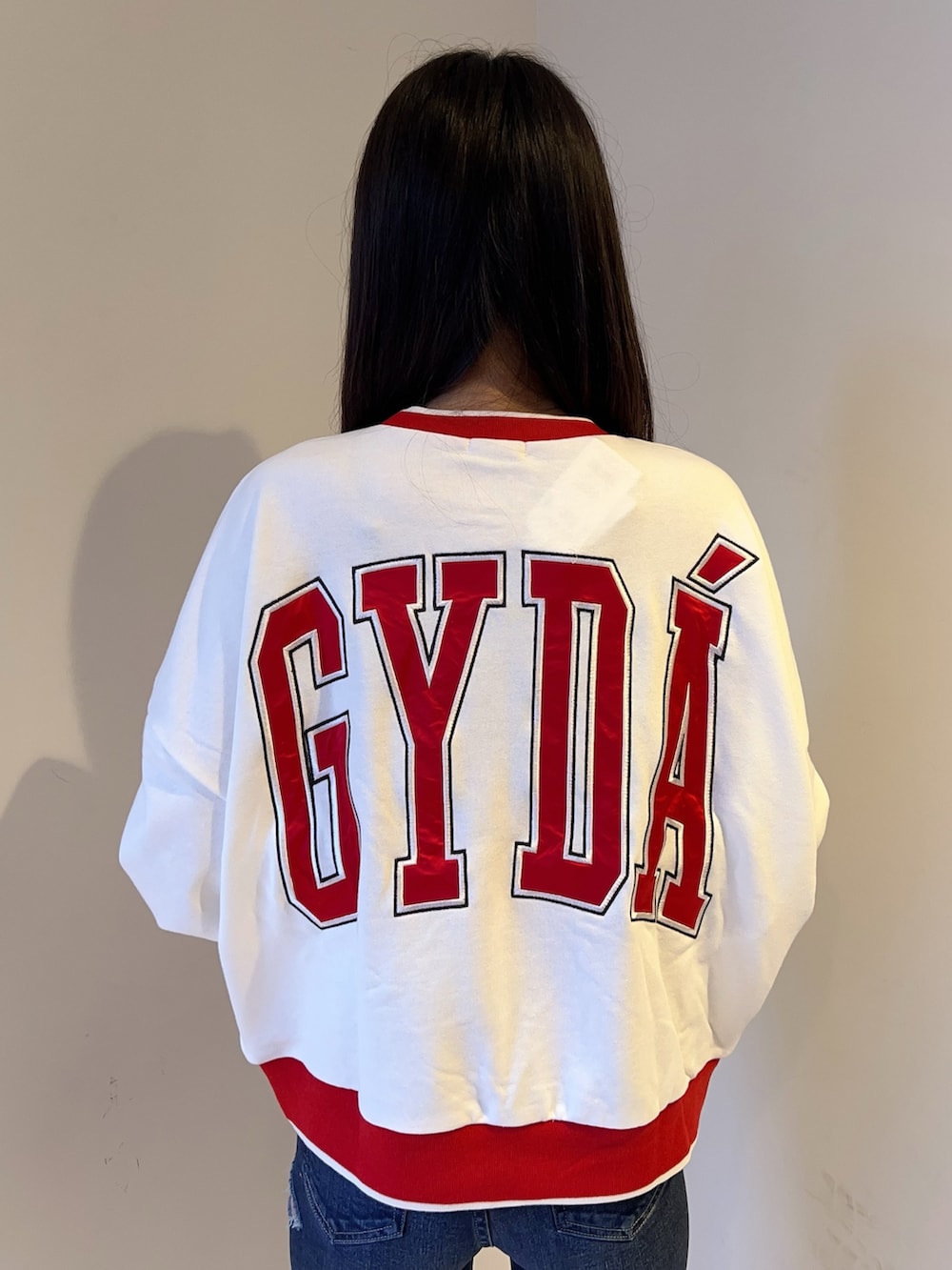 ホワイト系のスウェット、ブルー系のデニムパンツ、ブラック系のブーツを着用したレディースの夏コーディネートの4枚目の写真