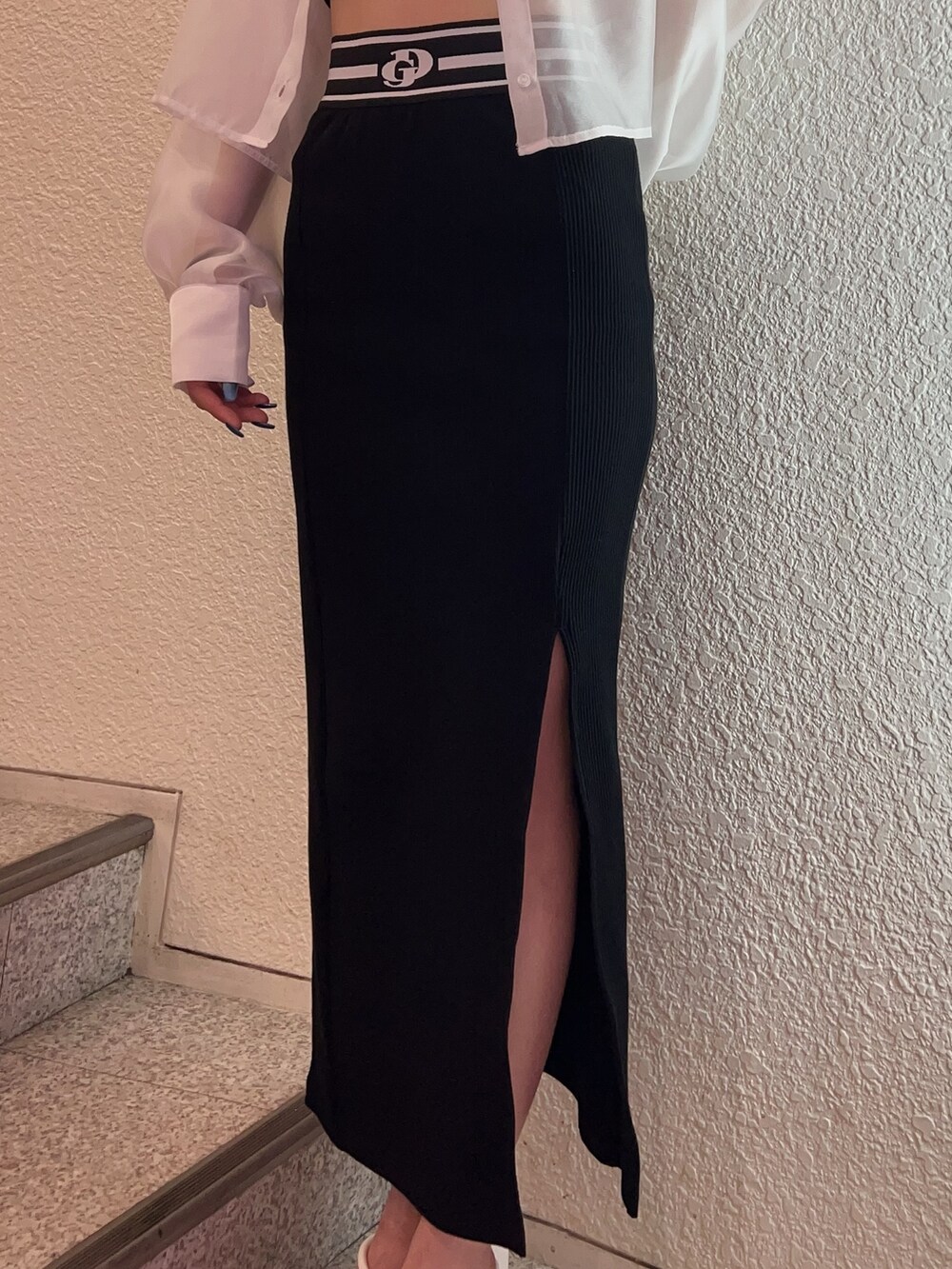 ホワイト系のシャツ/ブラウス、ブラック系のスカート、ホワイト系のサンダルを着用したレディースの春コーディネートの5枚目の写真