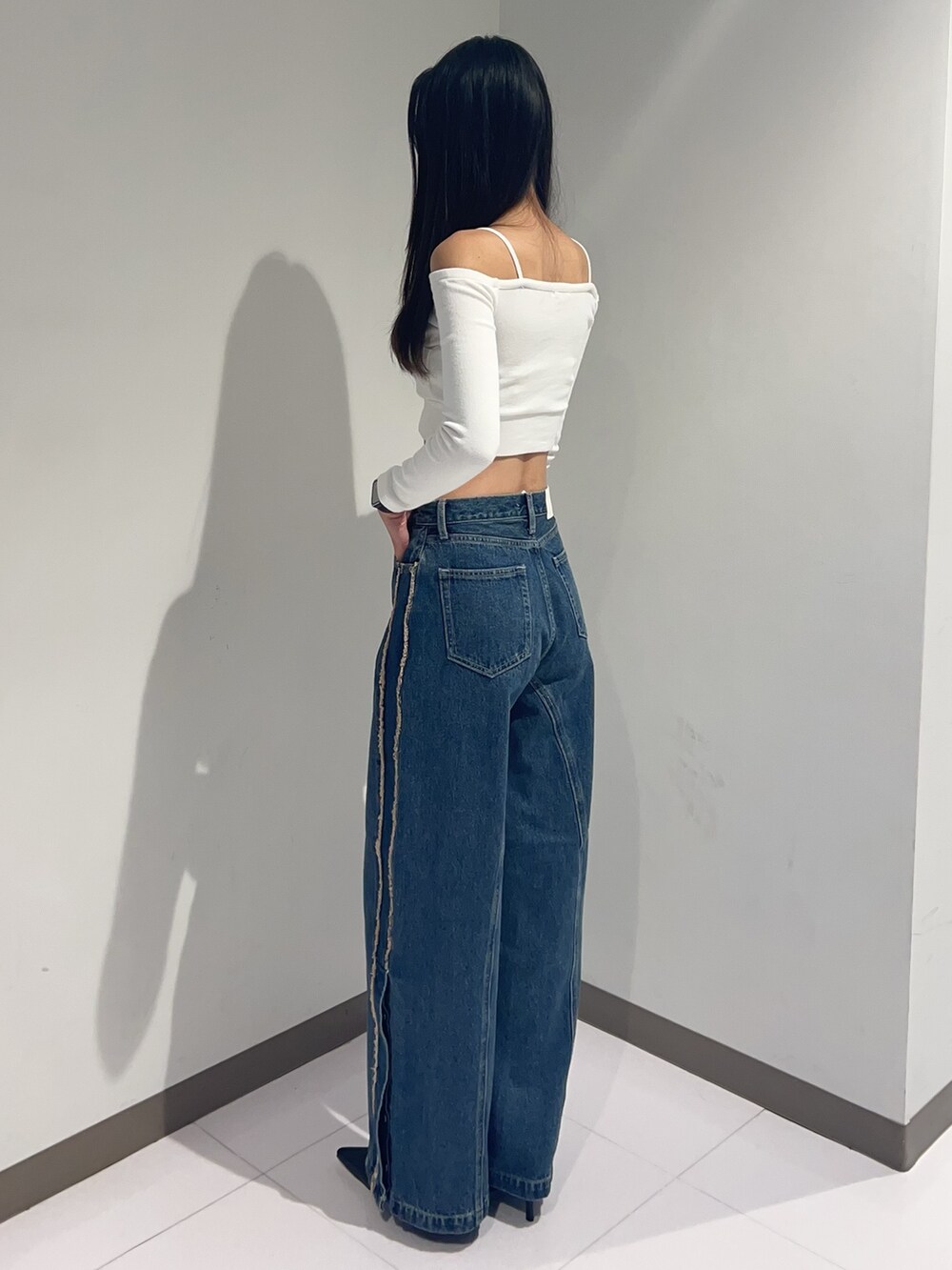 ホワイト系のTシャツ/カットソー、ブルー系のデニムパンツ、ブラック系のパンプスを着用したレディースの秋コーディネートの2枚目の写真