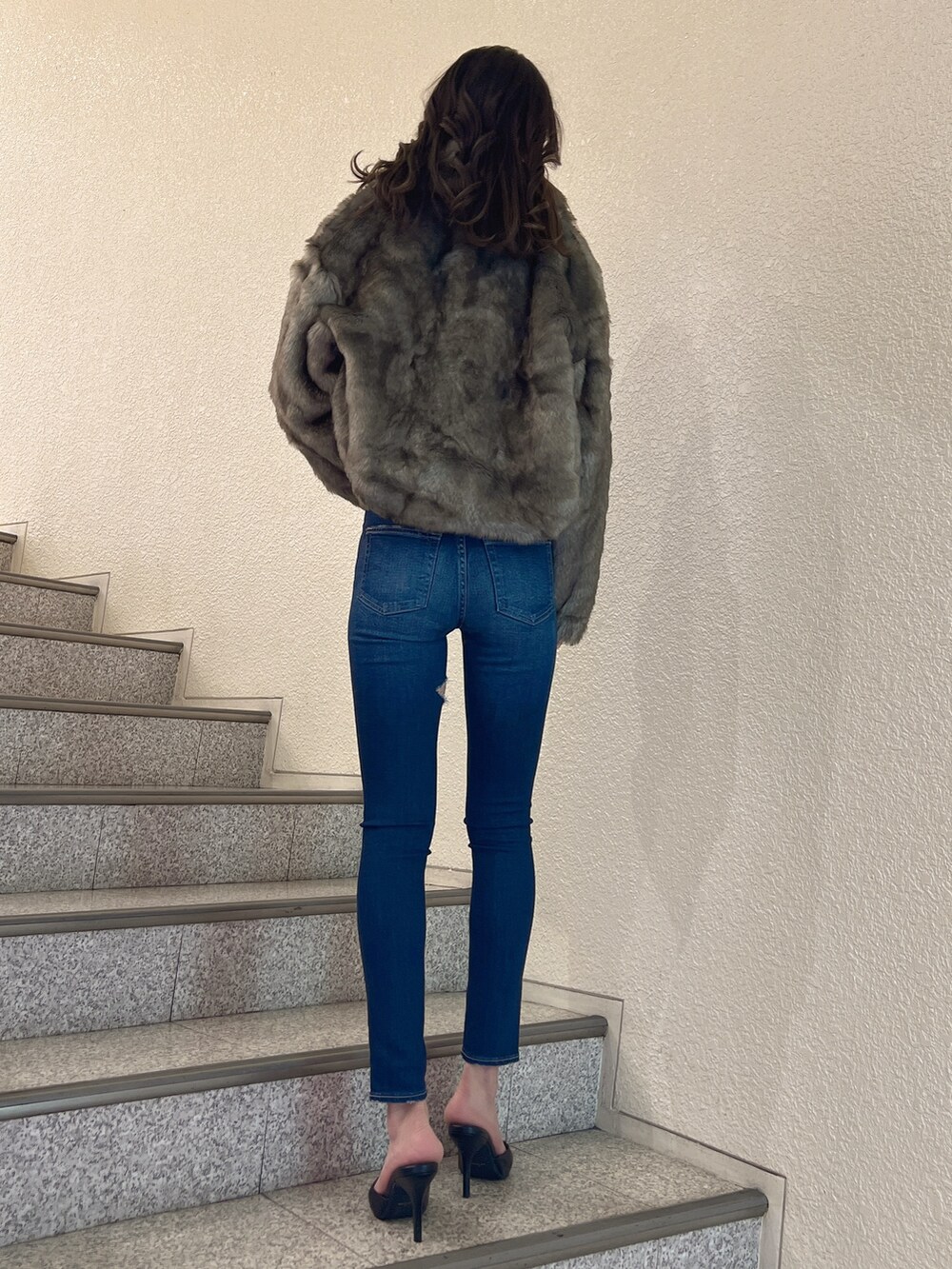 グレー系のその他アウター、ブルー系のデニムパンツ、ブラック系のパンプスを着用したレディースの秋コーディネートの3枚目の写真