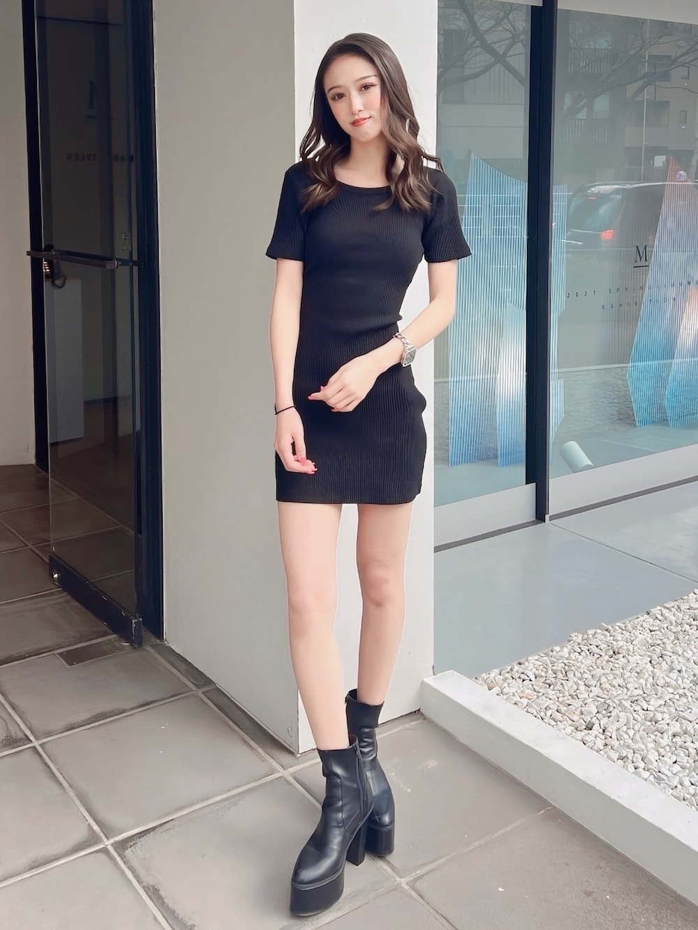 ブラック系のワンピース、ブラック系のブーツ、ホワイト系のブラジャーを着用したレディースの春コーディネートの3枚目の写真