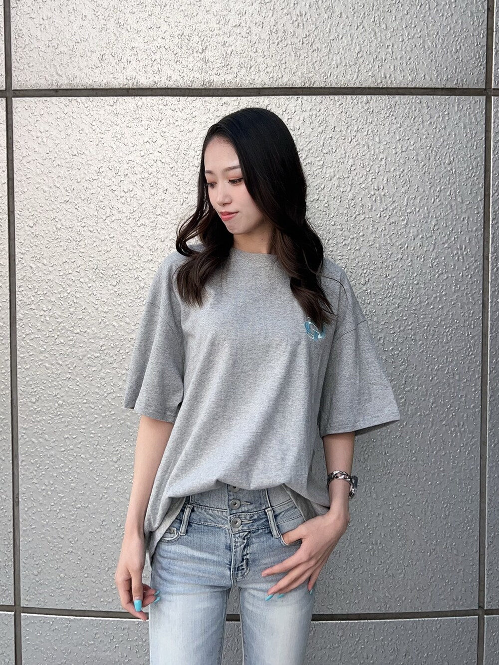 グレー系のTシャツ/カットソー、ブルー系のデニムパンツ、ホワイト系のパンプスを着用したレディースの春コーディネートの4枚目の写真