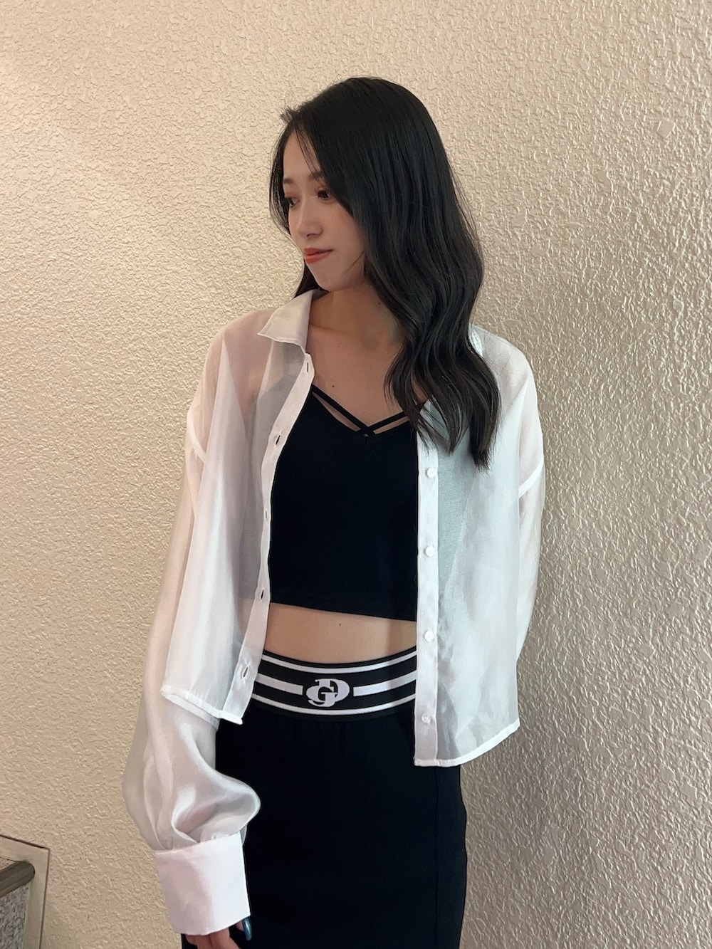 ホワイト系のシャツ/ブラウス、ブラック系のスカート、ホワイト系のサンダルを着用したレディースの春コーディネートの4枚目の写真