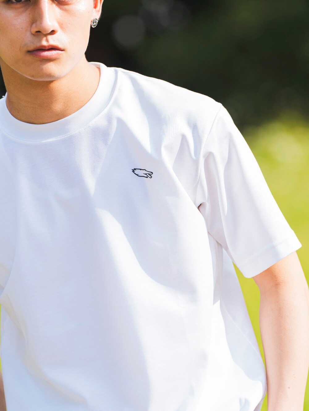 ホワイト系のTシャツ/カットソー、グリーン系のその他パンツ、ブラック系のスリッポンを着用したメンズの夏コーディネートの3枚目の写真