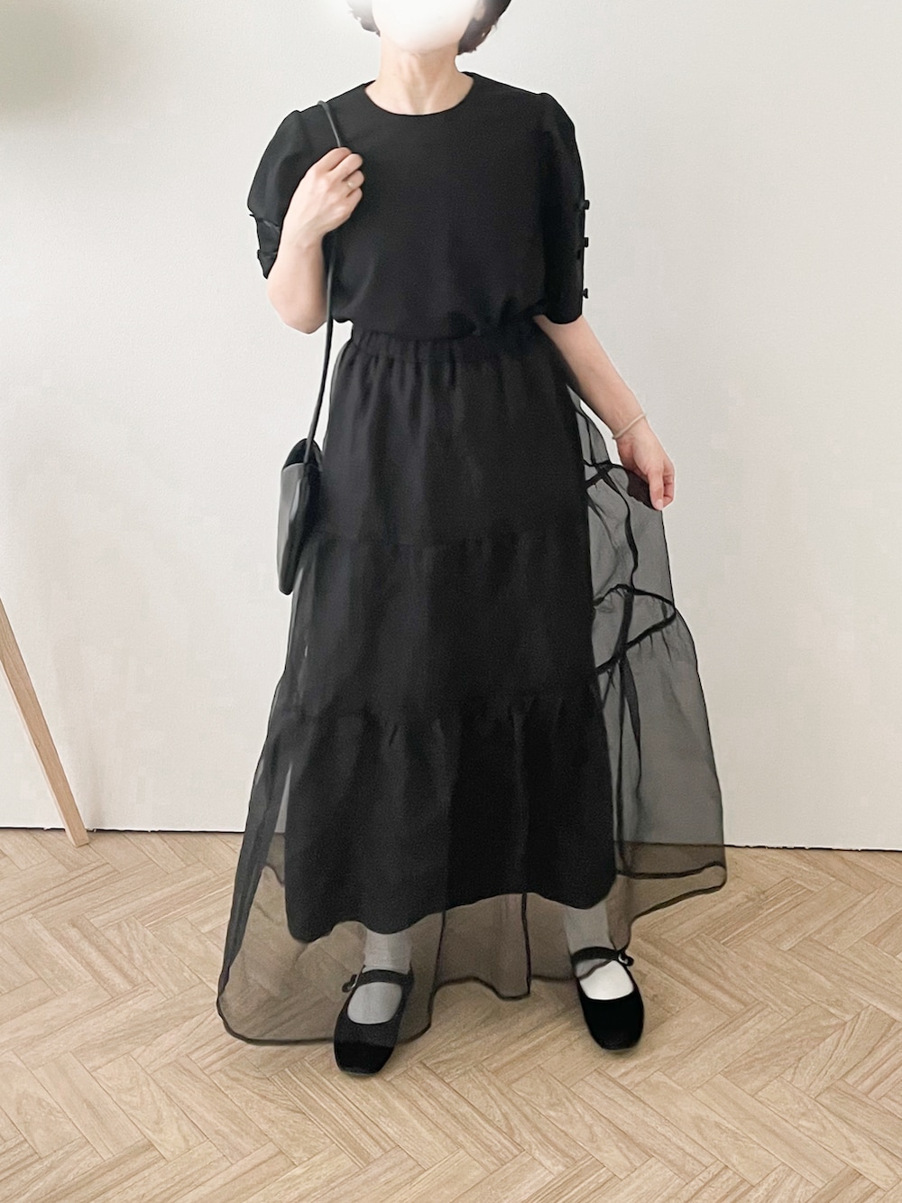 ブラック系のシャツ/ブラウス、ブラック系のスカート、ブラック系のハンドバッグを着用したレディースの夏コーディネートの2枚目の写真