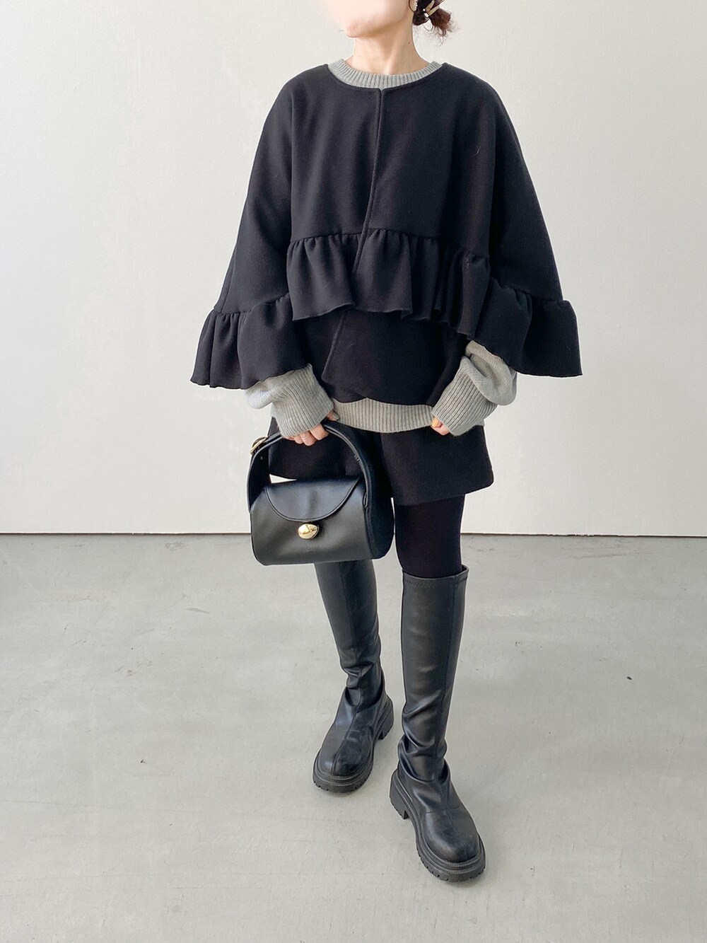 ブラック系のノーカラージャケット、ブラック系のブーツ、ブラック系のその他パンツを着用したレディースの秋コーディネートの2枚目の写真