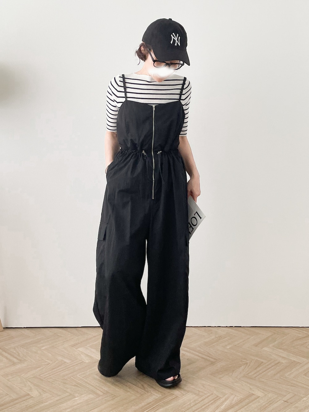 ブラック系のサロペット/オーバーオール、ホワイト系のTシャツ/カットソー、ブラック系のサンダルを着用したレディースの夏コーディネートの2枚目の写真