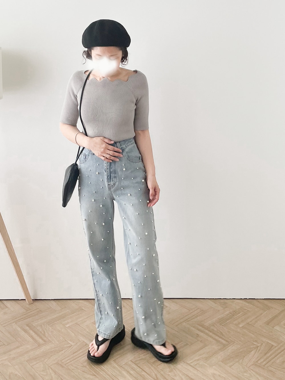 ブルー系のデニムパンツ、グレー系のニット/セーター、ブラック系のハンドバッグを着用したレディースの夏コーディネートの2枚目の写真