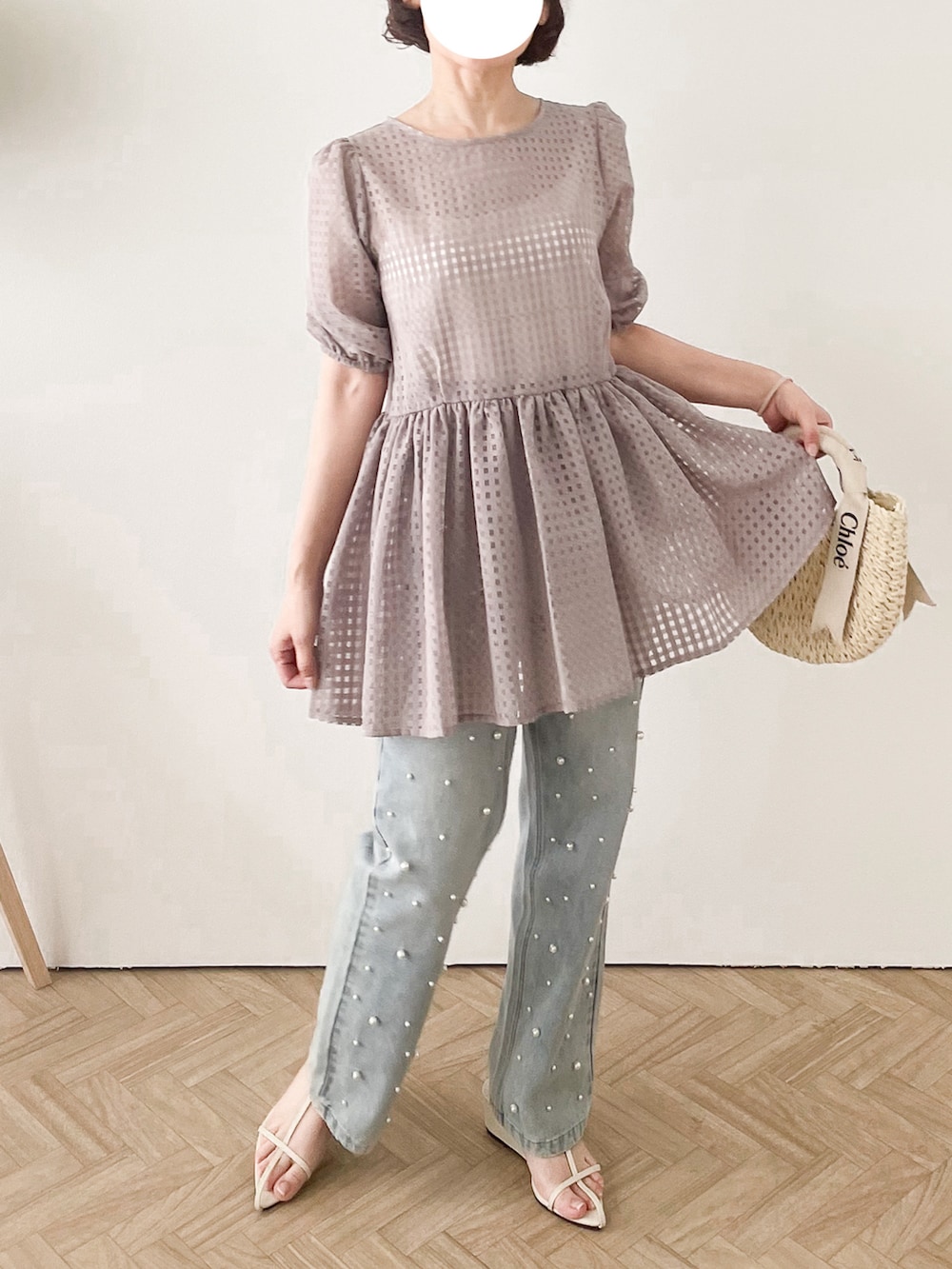 ベージュ系のTシャツ/カットソー、ブルー系のデニムパンツ、ホワイト系のサンダルを着用したレディースの夏コーディネートの2枚目の写真