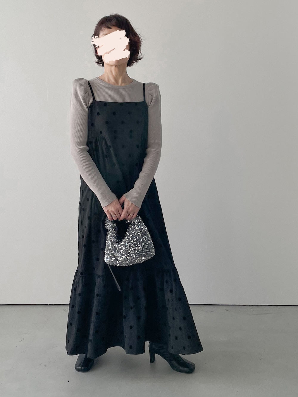 グレー系のハンドバッグ、その他のワンピース、ブラック系のブーツを着用したレディースの冬コーディネートの2枚目の写真