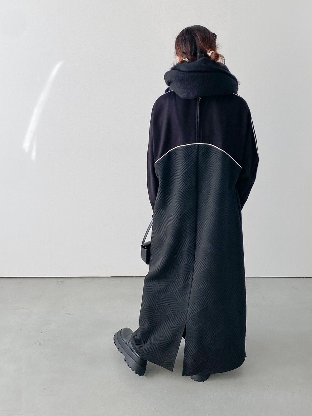 ブラック系のワンピース、ブラック系のブーツを着用したレディースの秋コーディネートの2枚目の写真