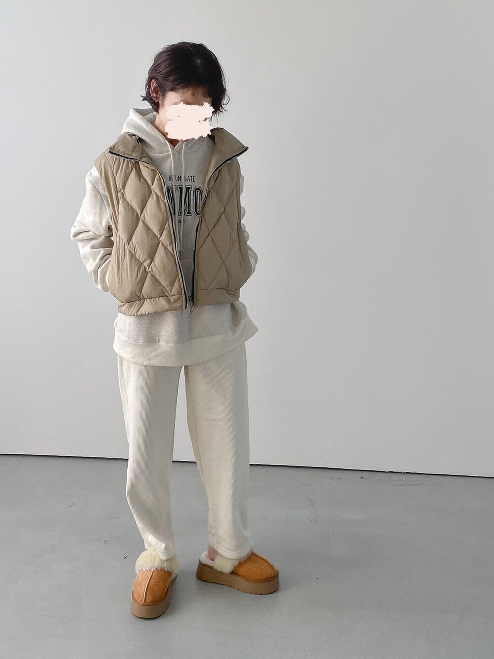 ベージュ系のベスト、ホワイト系のその他パンツを着用したレディースの冬コーディネートの2枚目の写真