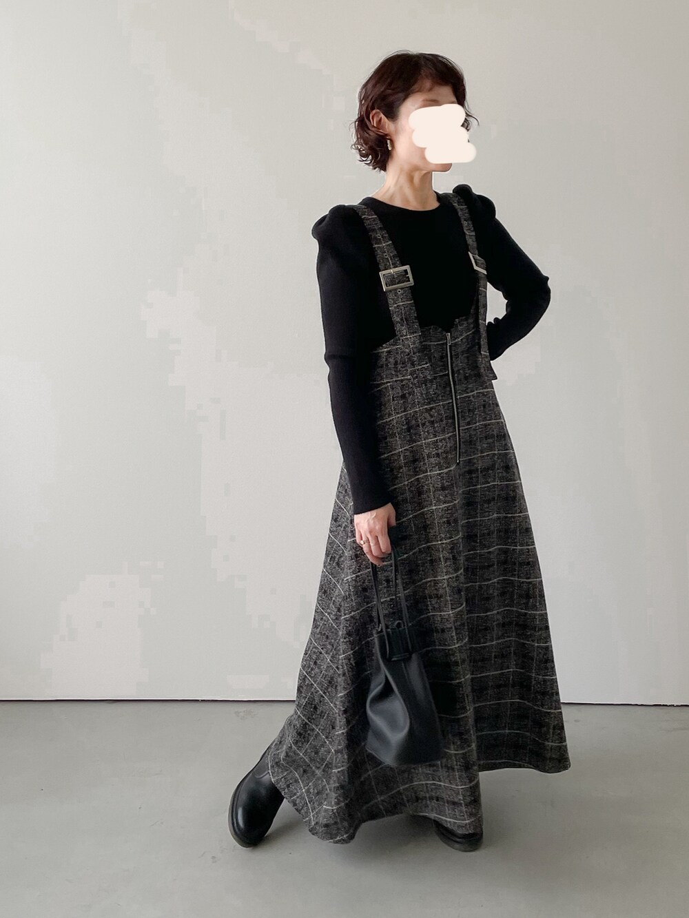 グレー系のスカート、ブラック系のブーツを着用したレディースの冬コーディネートの2枚目の写真