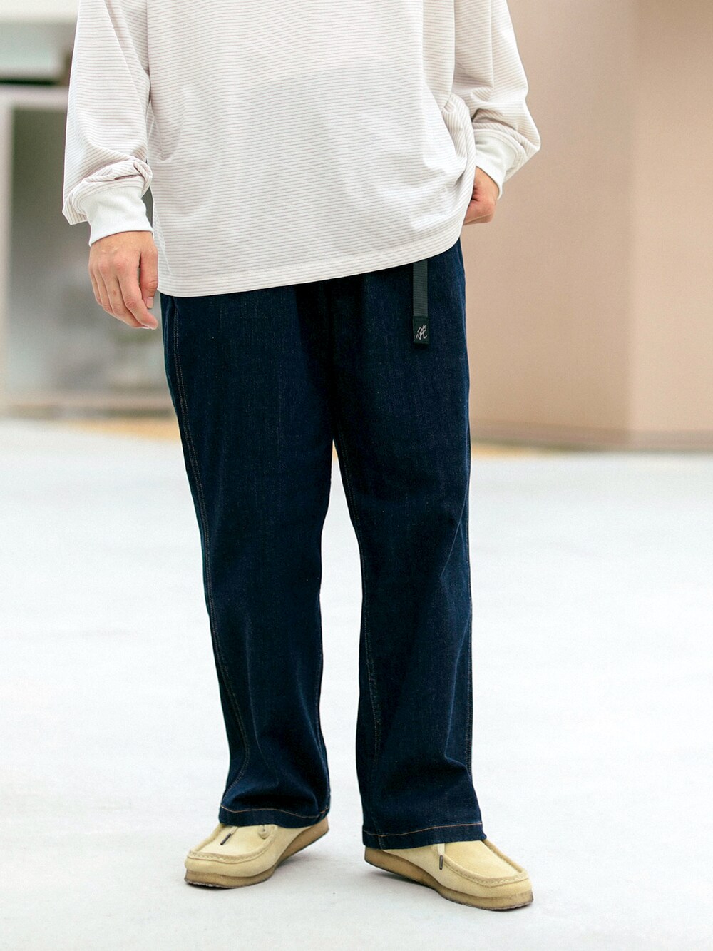 ベージュ系のTシャツ/カットソー、ブルー系のデニムパンツを着用したメンズの秋コーディネートの4枚目の写真