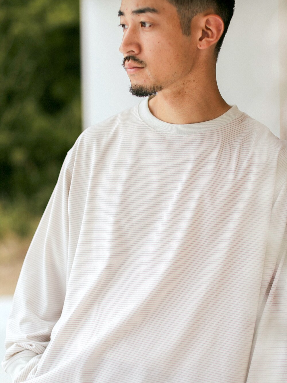 ベージュ系のTシャツ/カットソー、ブルー系のデニムパンツを着用したメンズの秋コーディネートの3枚目の写真