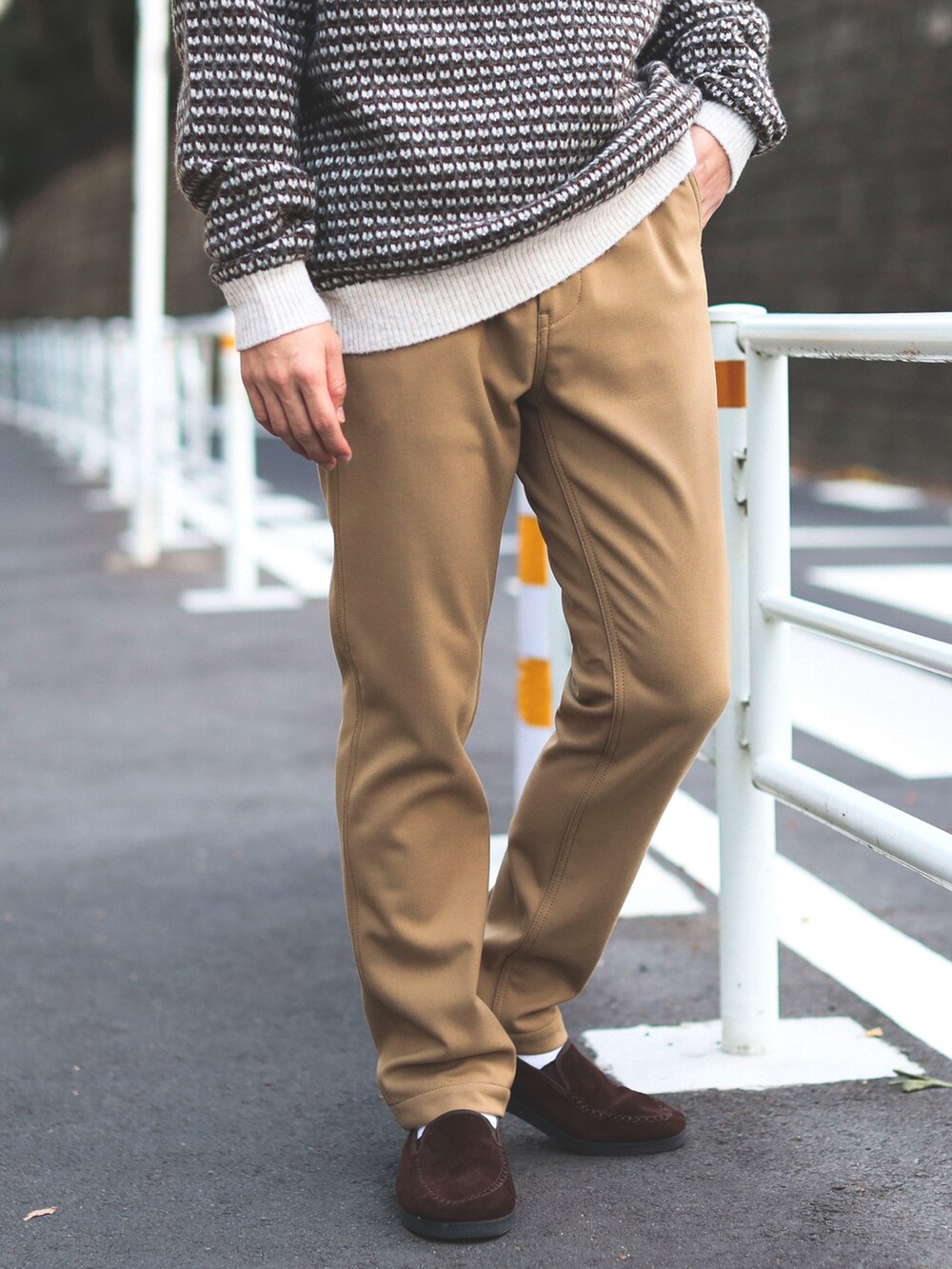 ホワイト系のニット/セーター、ベージュ系のチノパンツを着用したメンズの秋コーディネートの4枚目の写真