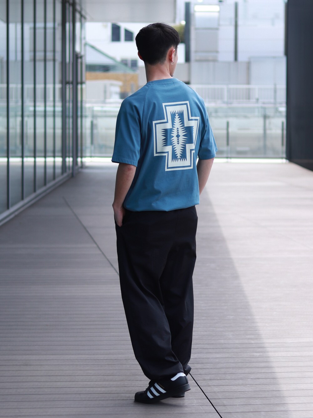 ブルー系のTシャツ/カットソーを着用したメンズの春コーディネートの2枚目の写真