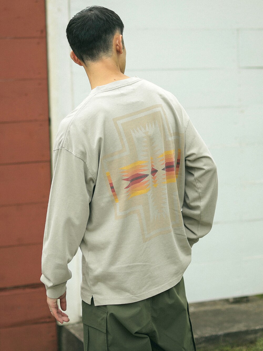 ベージュ系のTシャツ/カットソー、グリーン系のカーゴパンツを着用したメンズの秋コーディネートの3枚目の写真