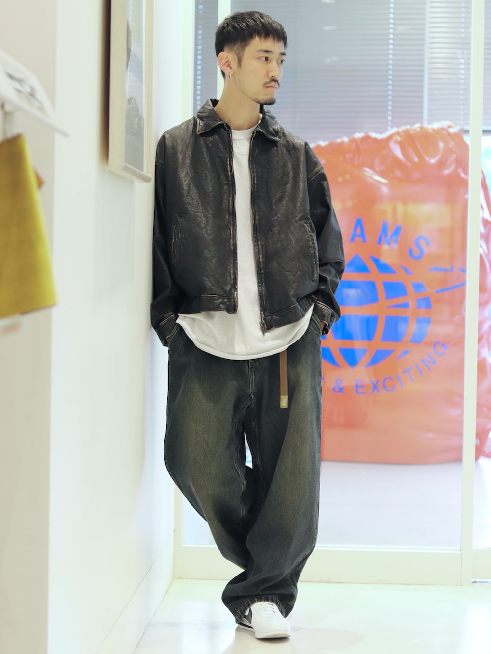 ブルー系のデニムパンツ、ブラック系のブルゾンを着用したメンズの夏コーディネートの2枚目の写真