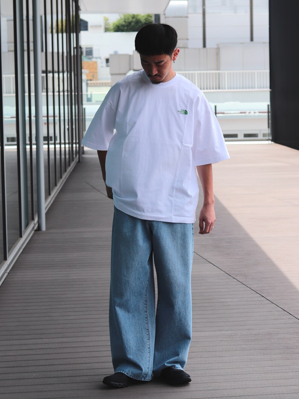 ブルー系のデニムパンツ、ホワイト系のTシャツ/カットソーを着用したメンズの春コーディネートの2枚目の写真