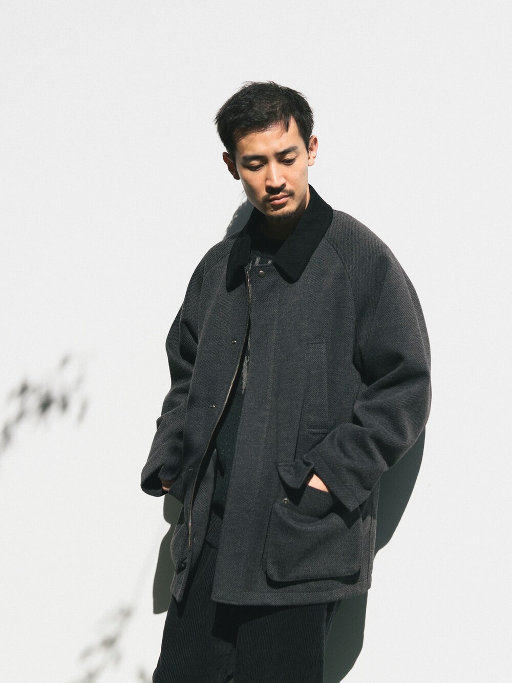 グレー系のブルゾン、グレー系のニット/セーターを着用したメンズの冬コーディネートの2枚目の写真