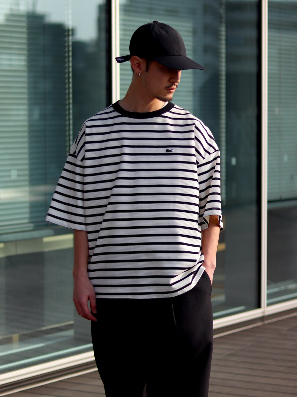 ホワイト系のTシャツ/カットソー、ブラック系のその他パンツ、ブラック系のキャップを着用したメンズの春コーディネートの3枚目の写真