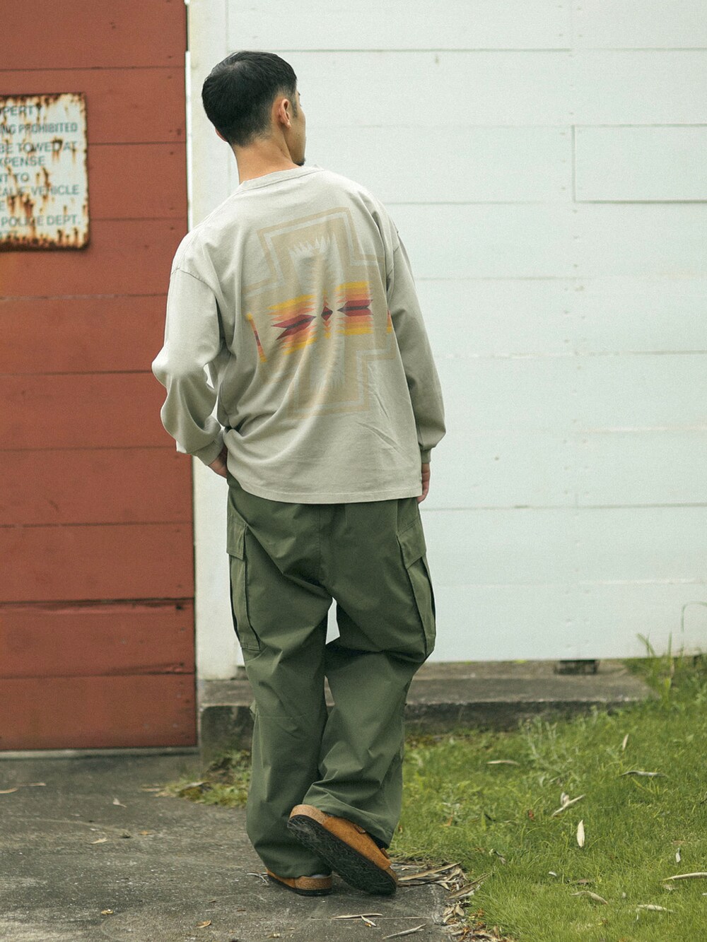 ベージュ系のTシャツ/カットソー、グリーン系のカーゴパンツを着用したメンズの秋コーディネートの2枚目の写真