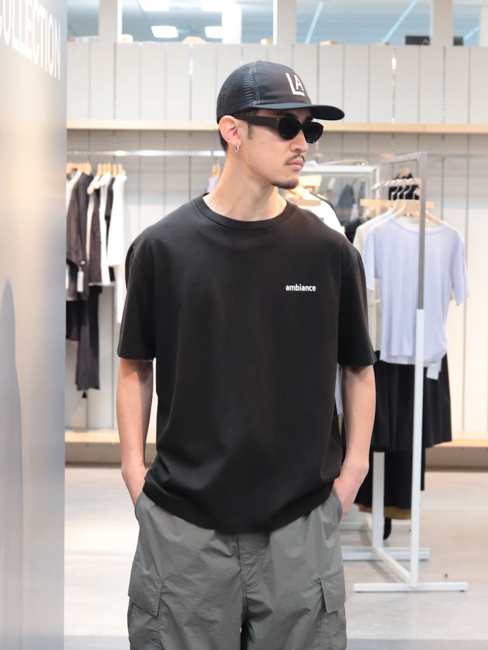 ブラック系のTシャツ/カットソー、グリーン系のカーゴパンツ、ブラック系のキャップを着用したメンズの春コーディネートの3枚目の写真